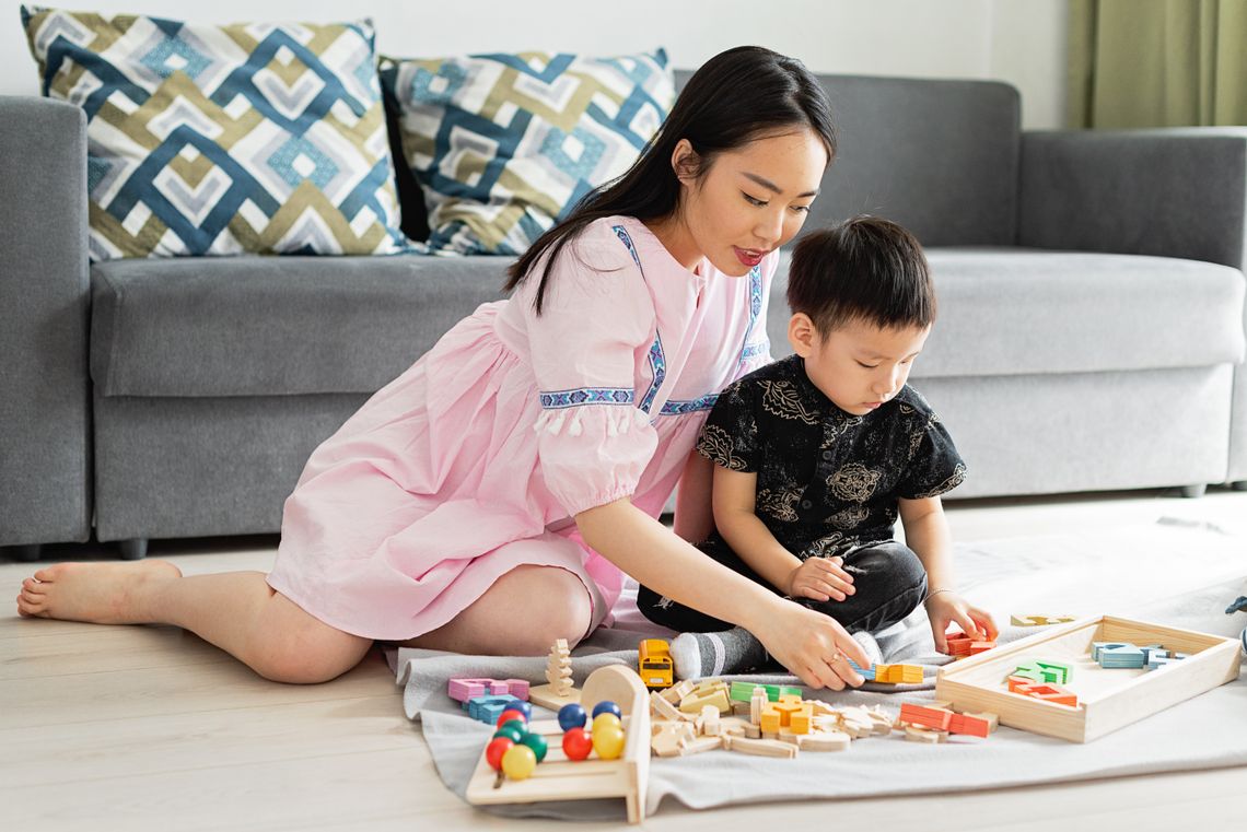 Mother and young son bonding while playing with educational toys at home