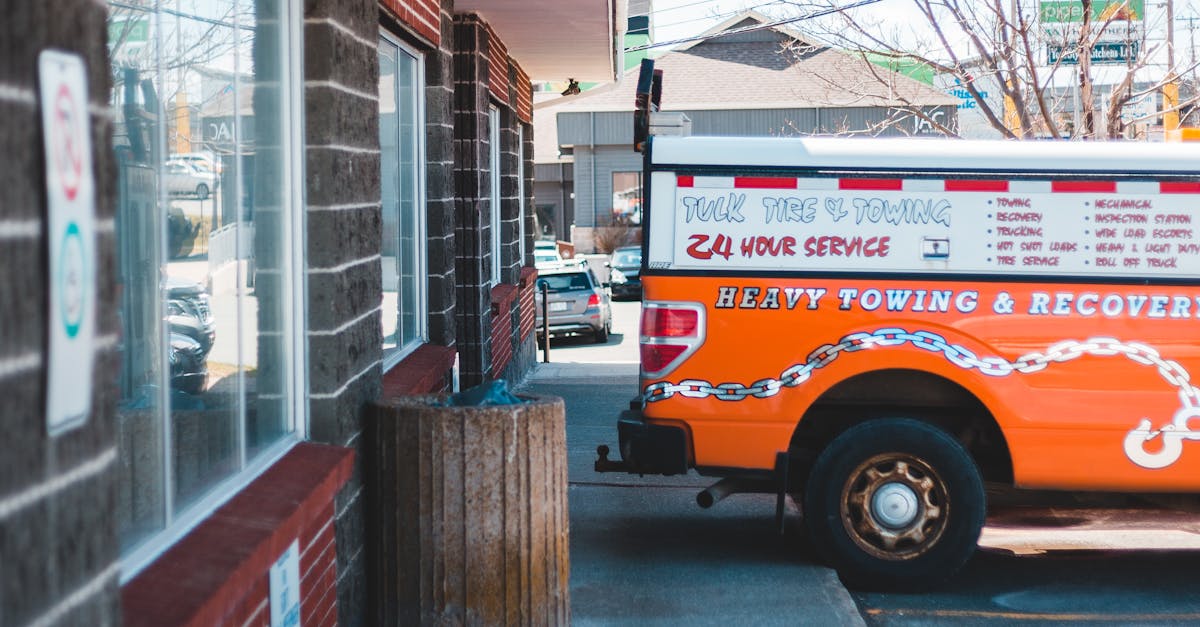 Photo by Erik Mclean Colorful towing truck parked alongside an industrial building on a sunny day.