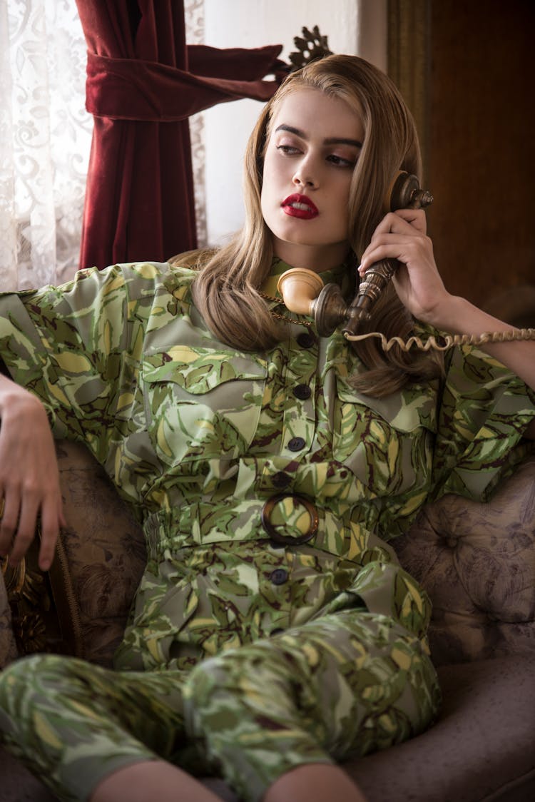 Woman Dressed In Camouflage Print Posing With A Vintage Telephone Handset