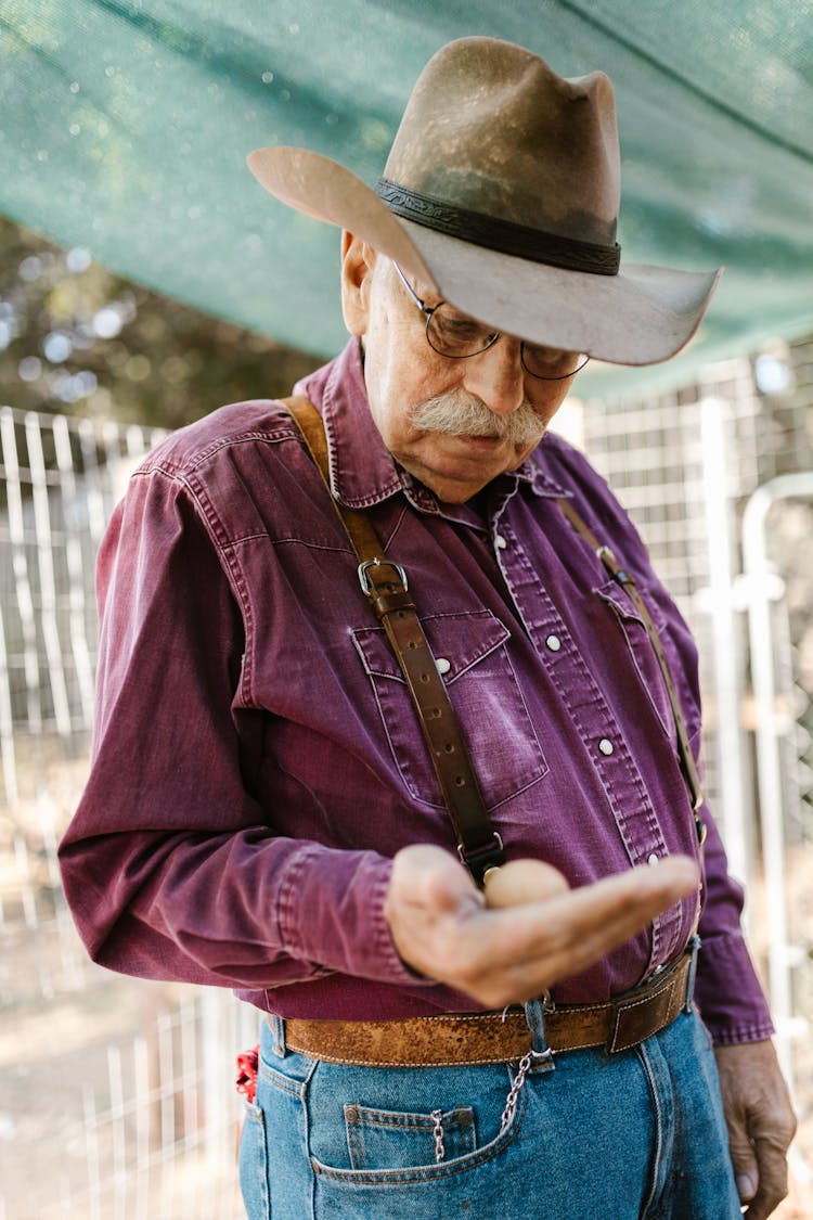 An Elderly Man Holding An Egg