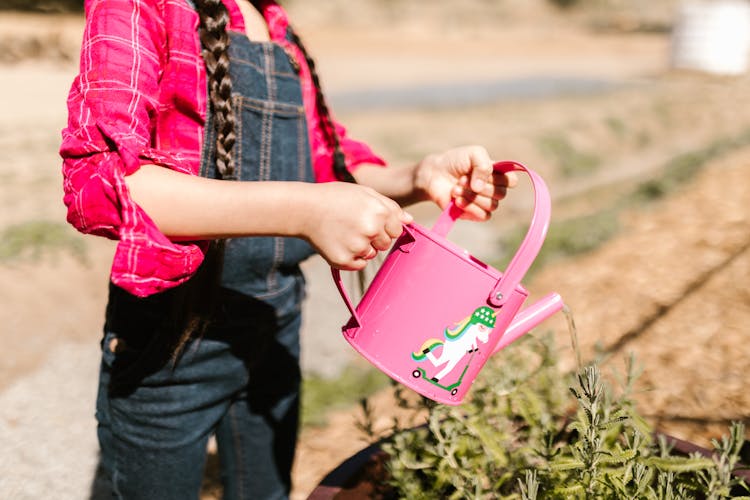 Close Up Photo Of Kid Holding A Watering Can