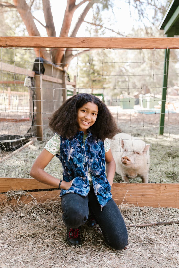 Woman Posing Beside A Pig On Fence 