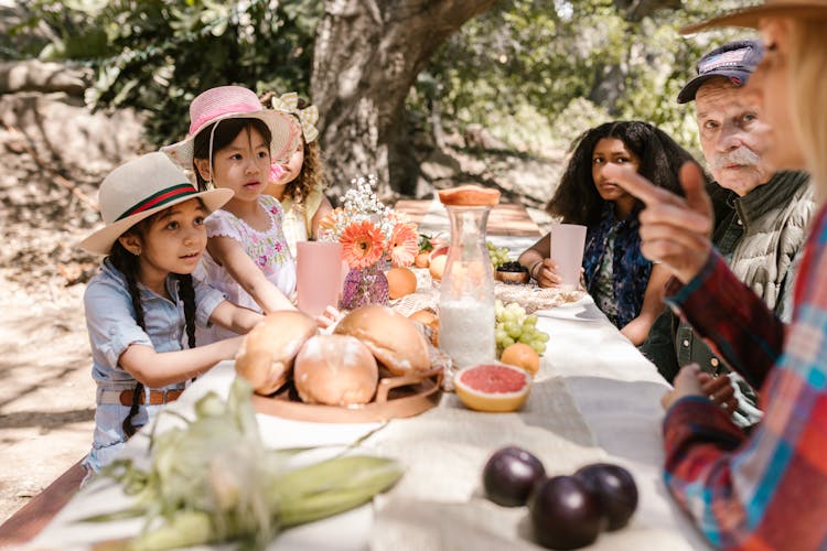 People Sitting Near The Table While Listening To The Woman Speaking