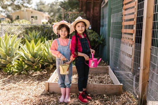 Children watering plants in a garden