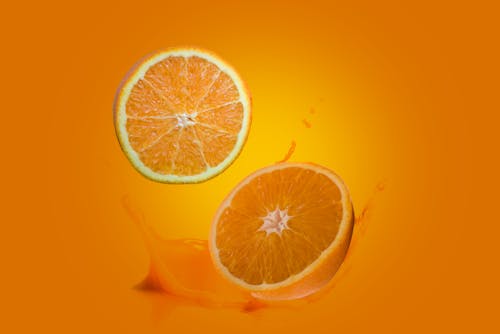 Free Sliced Orange Fruit on Orange Background Stock Photo