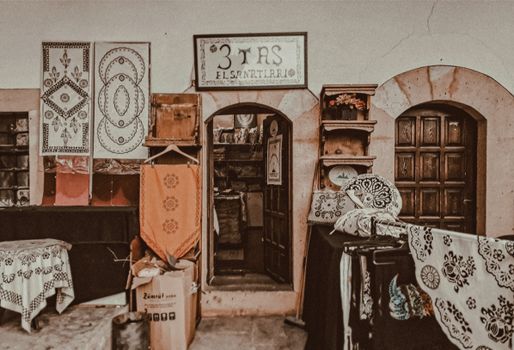 Explore a quaint textile shop featuring traditional patterns and rustic decor in a cozy setting.