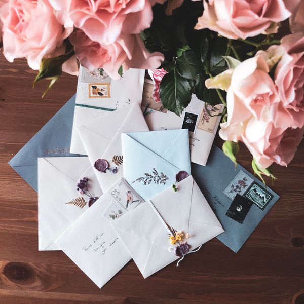 Envelopes finished with sealing wax beside roses — photo by Nur Yilmaz on Pexels