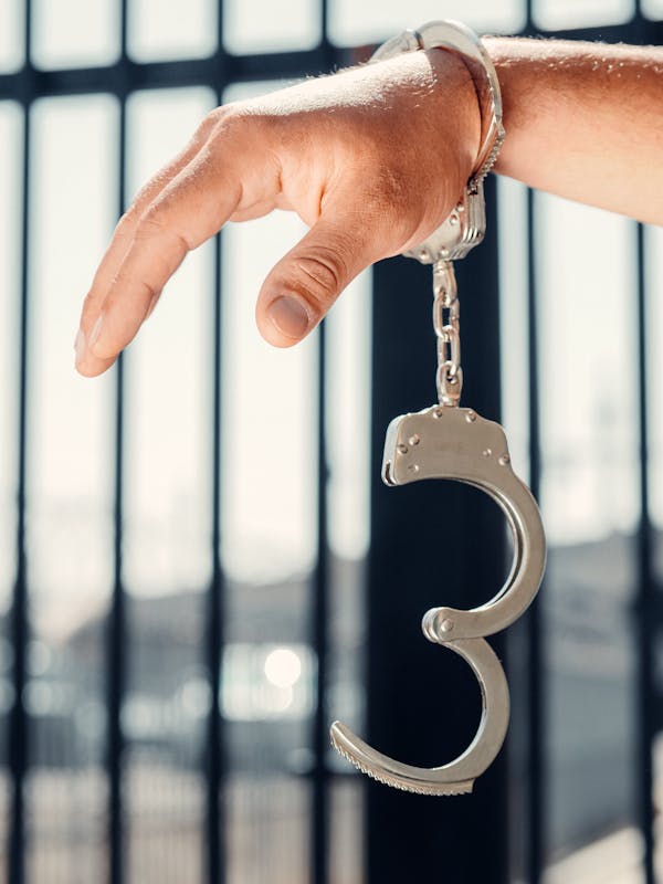 Photo of a Person's Hand with a Handcuff