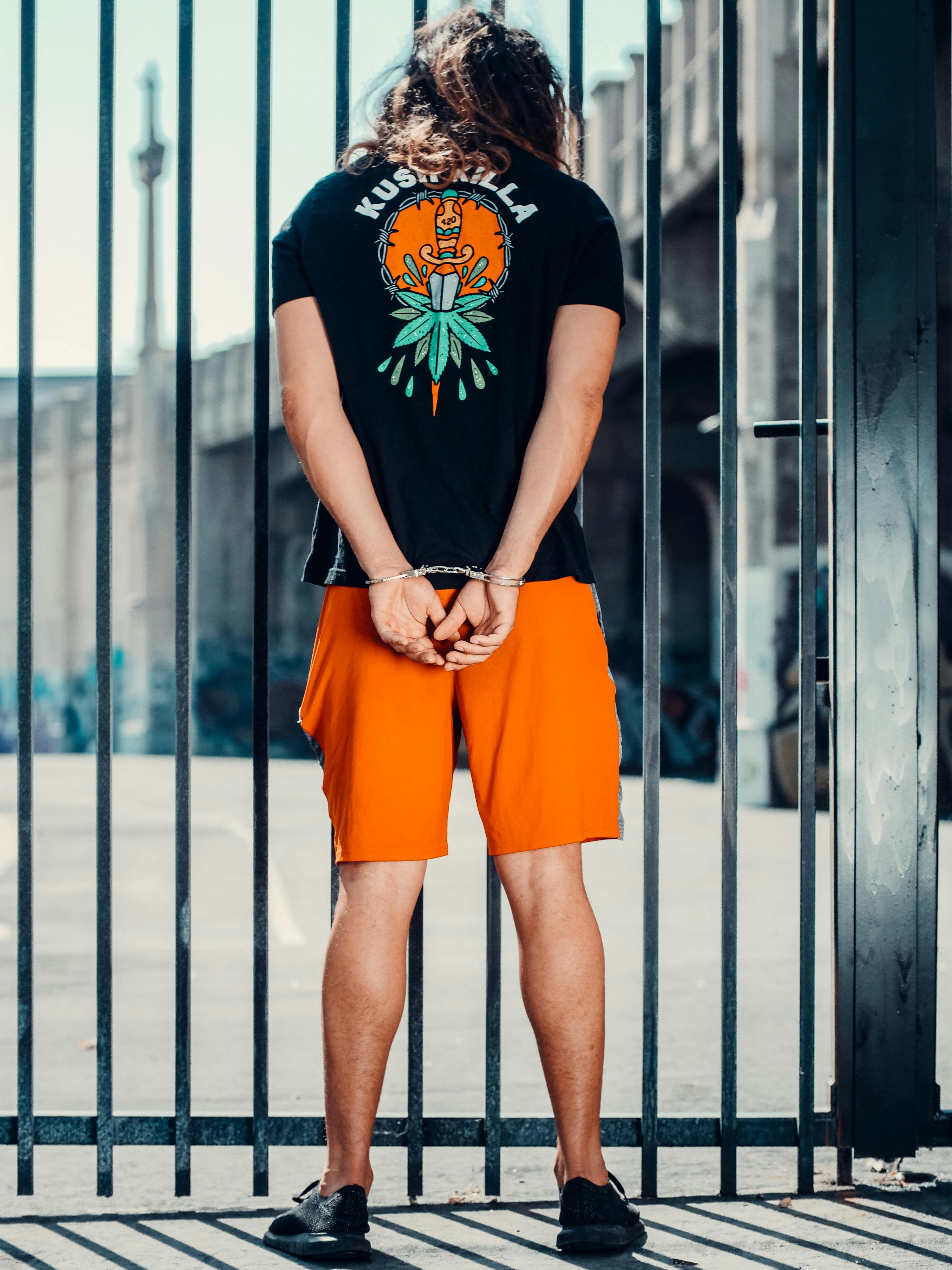 a man in handcuffs near a metal fence