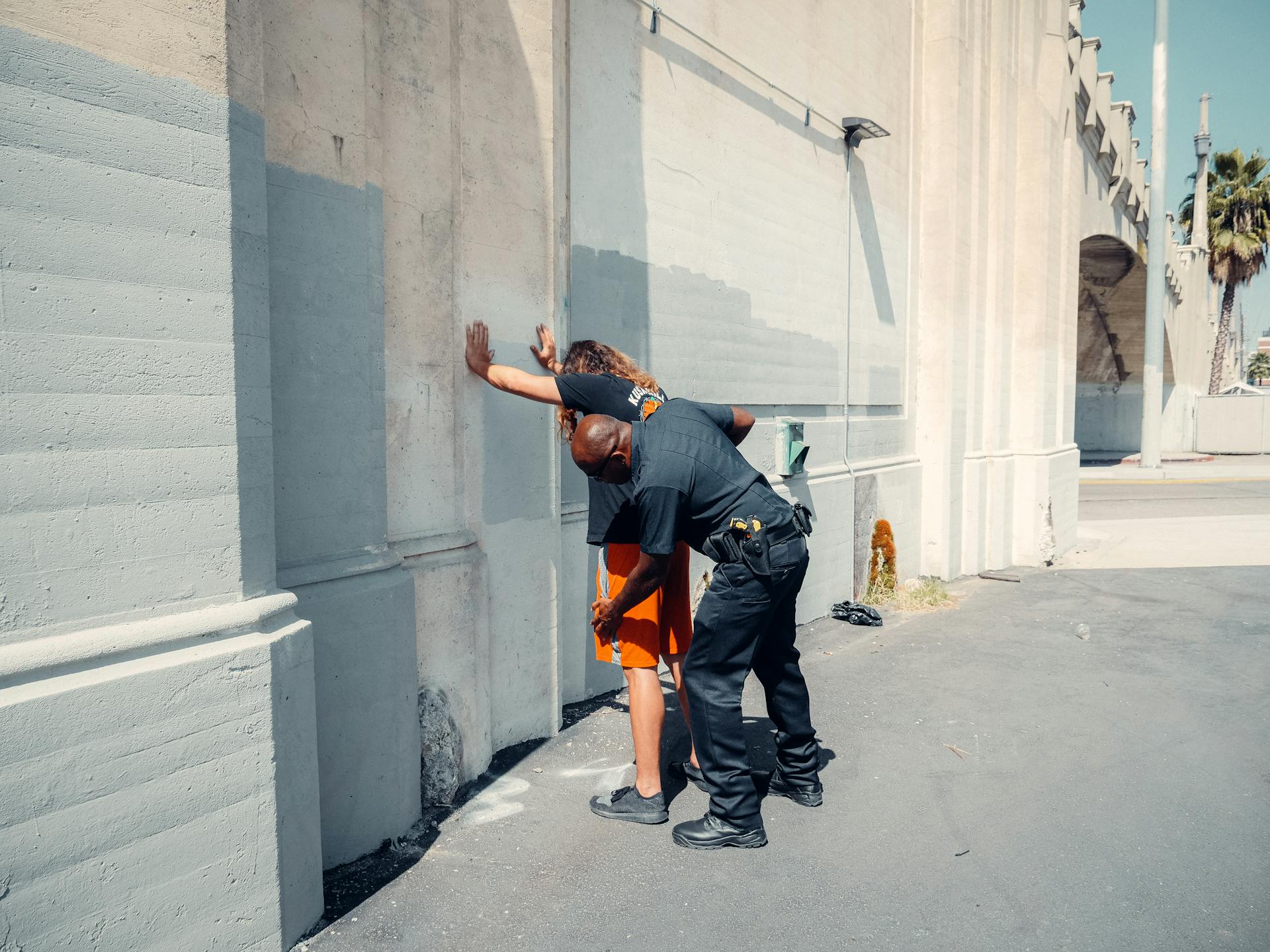 An Officer Frisking a Man