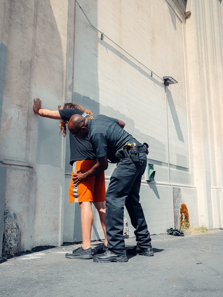 An Officer Frisking A Man