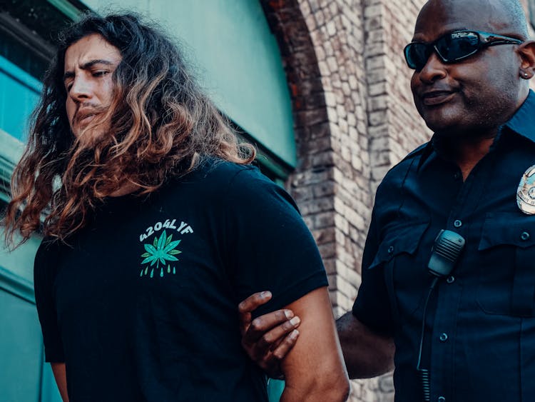 A Police Officer And A Man In A Black Shirt