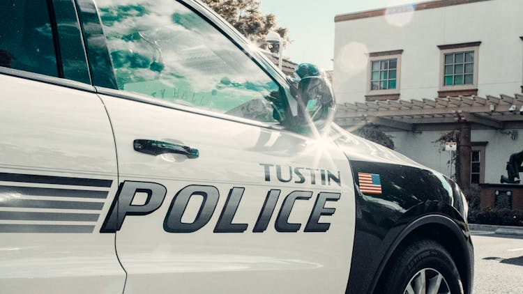 White And Black Police Car Parked Near Concrete House