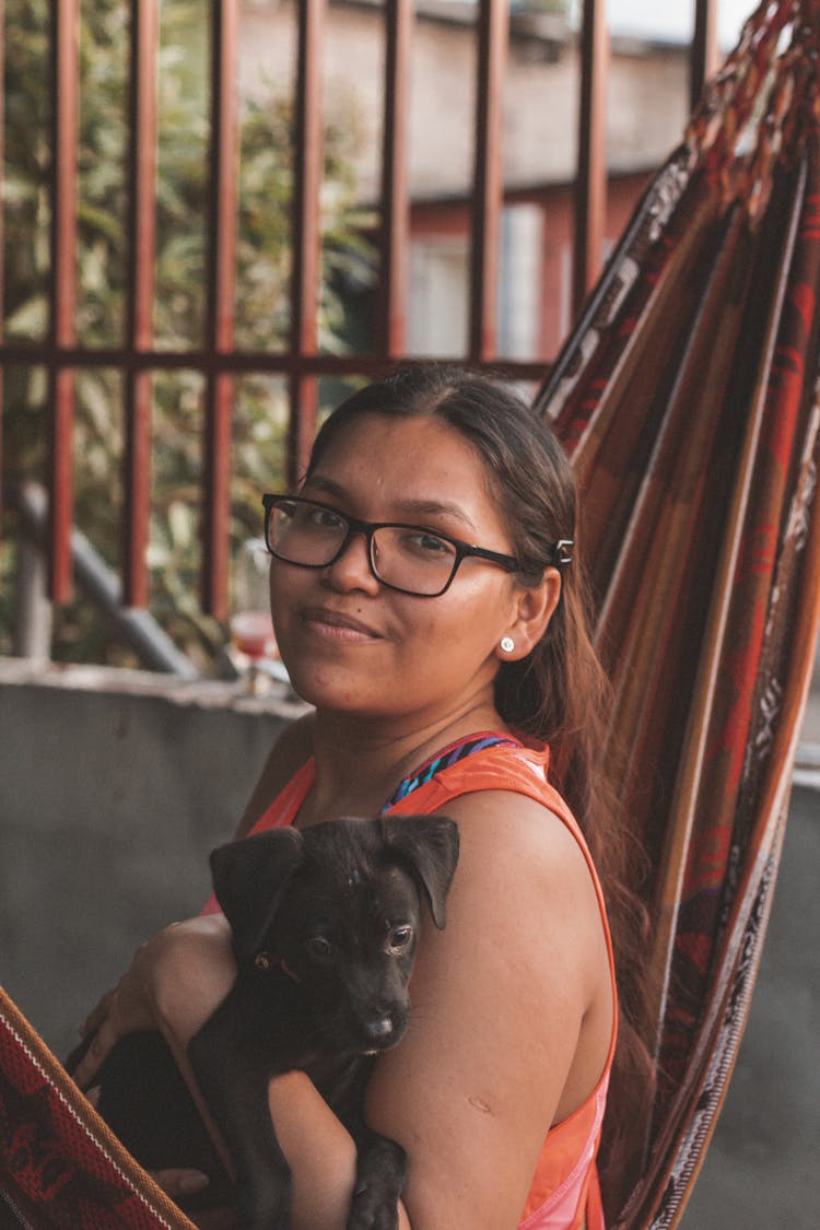 Woman Sitting On Hammock With A Dog