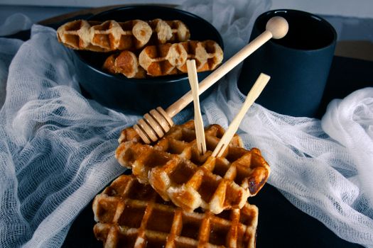Close-up of delicious waffles with honey drizzlers, perfect for a sweet breakfast or dessert.