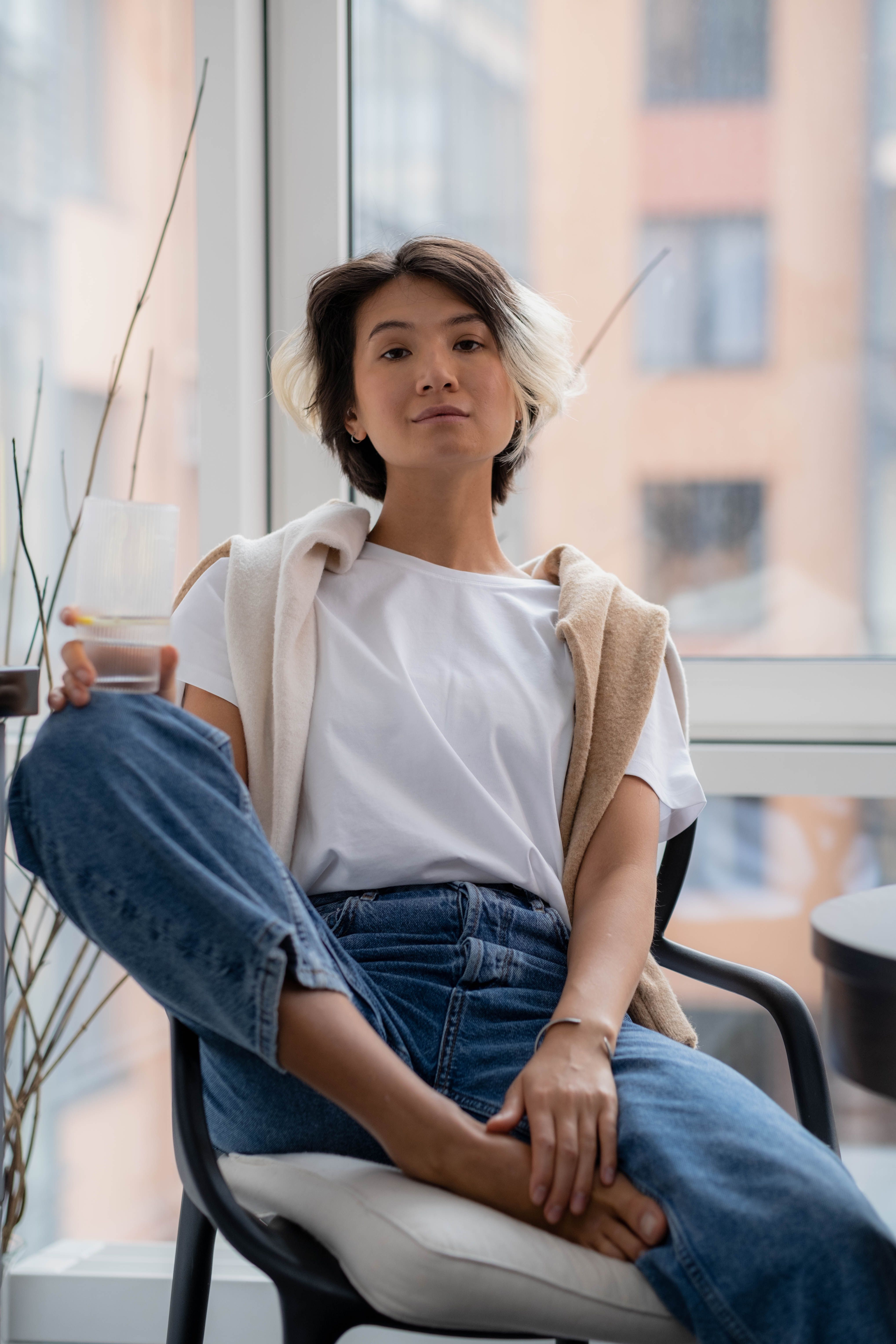 Woman in White Shirt and Blue Denim Jeans Sitting on Chair · Free Stock ...