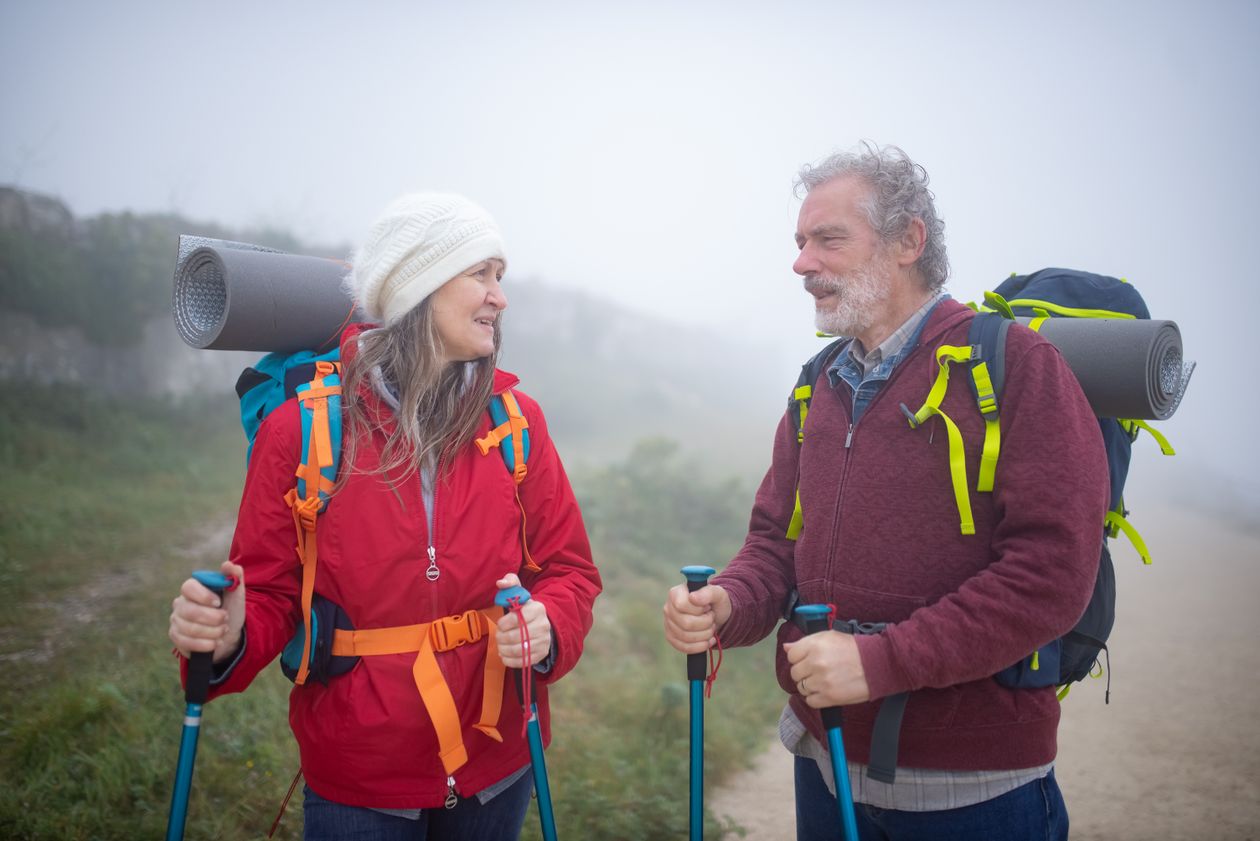 Active adults over 40 hiking with trekking poles, demonstrating the joint mobility and tendon resilience collagen peptides support