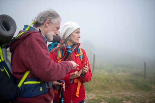 Free Two hikers consult a smartphone in a foggy rural landscape in Portugal. Stock Photo