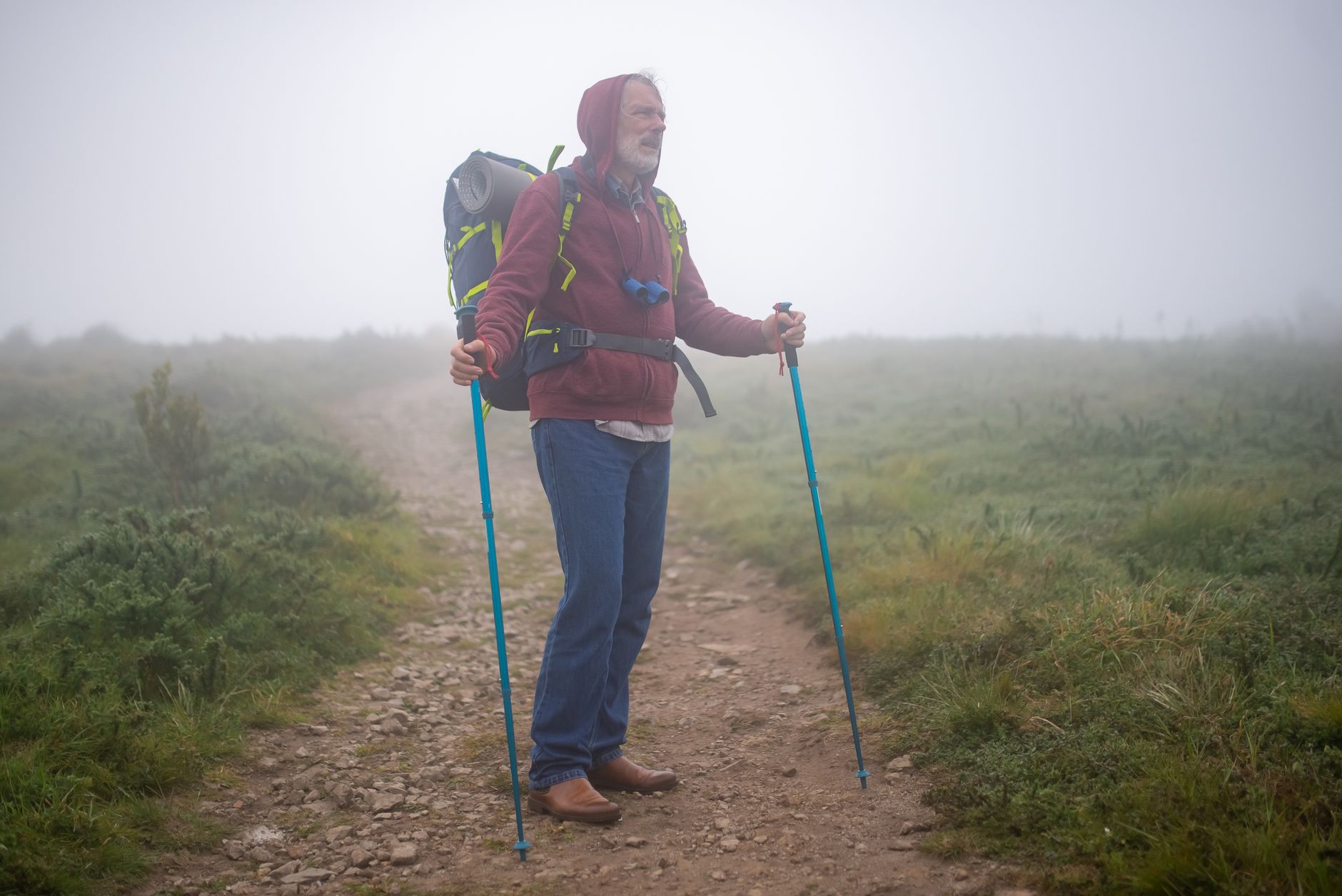 long covid natural recovery men over 50 — Senior man hiking on a foggy trail in Portugal, enjoying the outdoors and leisure trekking.