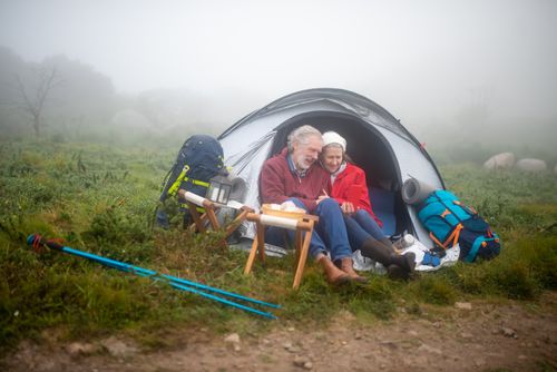 Free Elderly couple enjoys a cozy camping experience in a foggy Portuguese landscape, embracing nature and adventure. Stock Photo