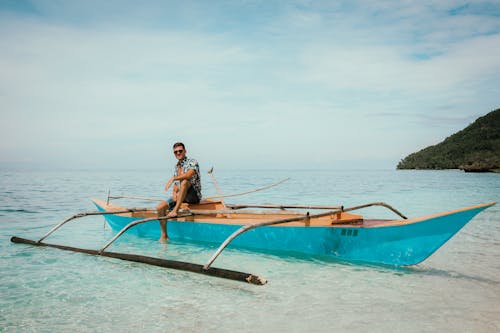 Guy sitting on wooden boat