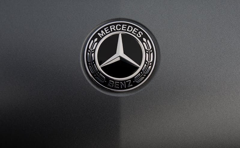 Detailed view of a luxury car logo on a sleek metallic surface.