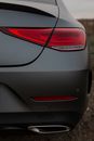 Back bumper of luxury stylish gray automobile with taillight switched off in rural area