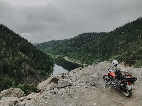 Motorbike on top of rocky cliff under mountain river