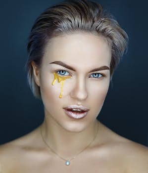 Portrait of a woman with unique golden makeup and confident expression.