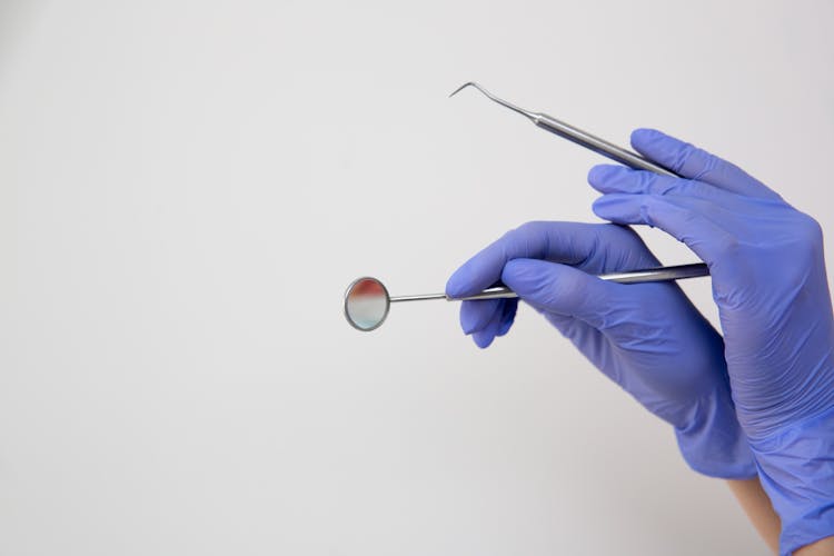 Crop Hand Of Dentist In Gloves With Instrument For Treatment