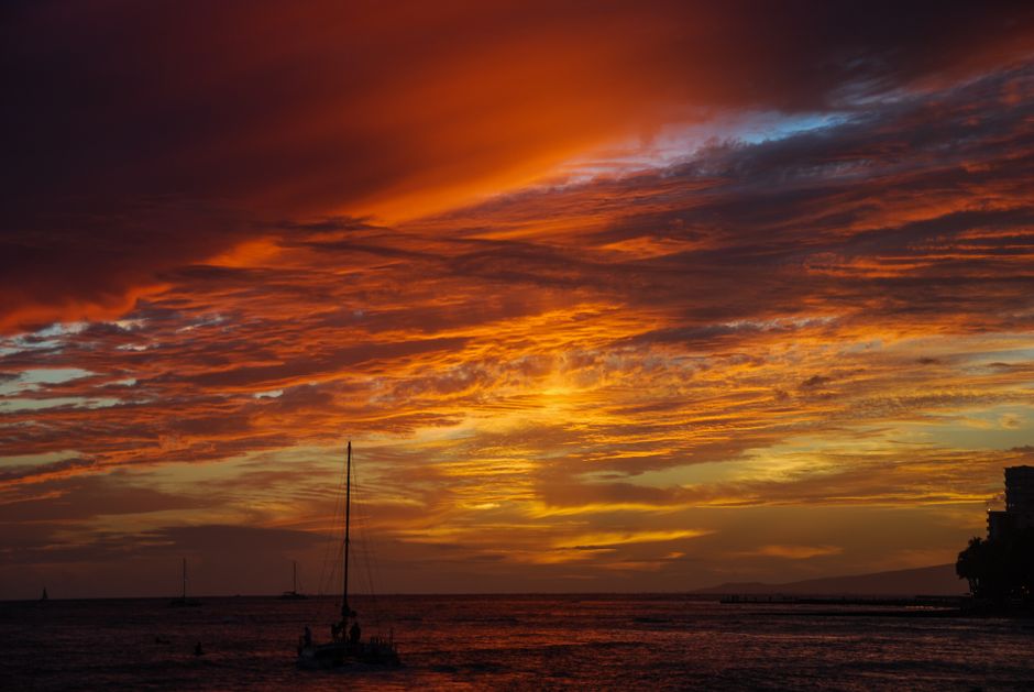 A stunning sunset over the ocean in Honolulu, casting vibrant colors across the sky.