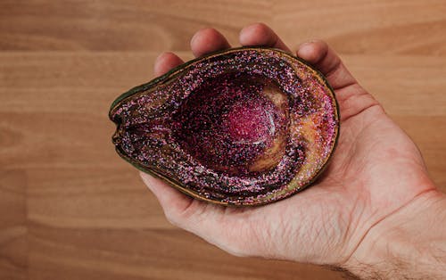Man showing rotten avocado with pink glitter