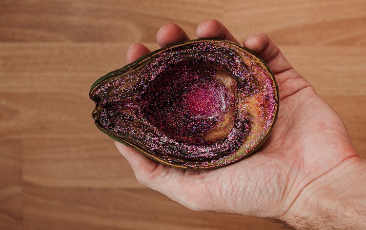 Man Showing Rotten Avocado With Pink Glitter