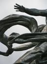 Dark steel sculpture against cloudy sky