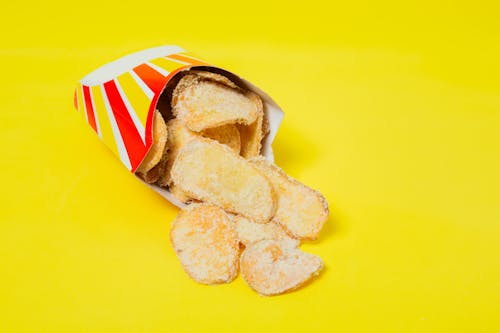 Delicious chips on yellow background