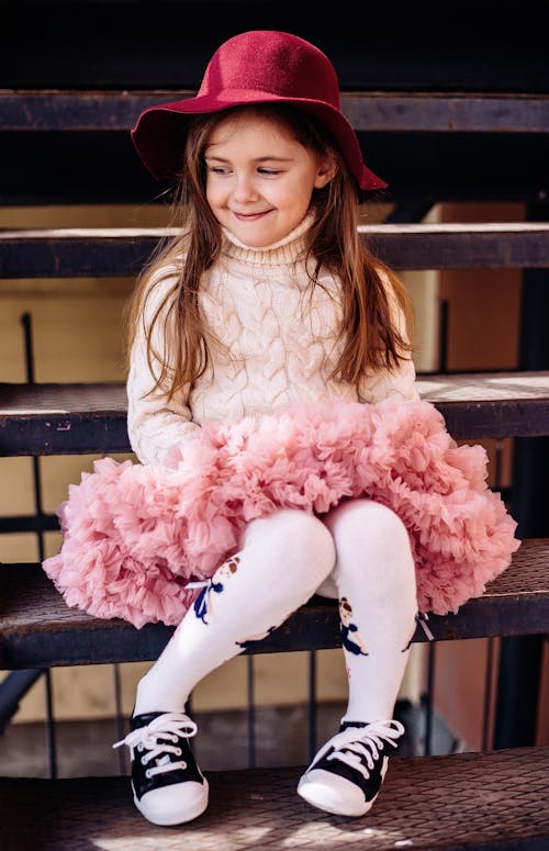 A Girl Wearing a Pink Dress with a Red Hat