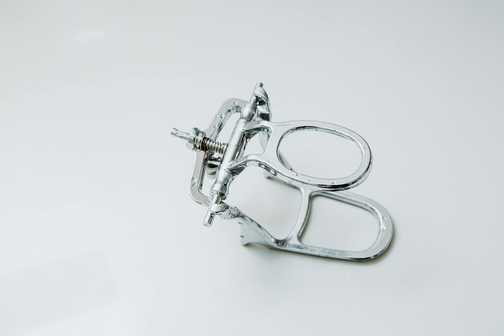 Detailed view of a metallic dental orthodontic instrument against a clean white background.