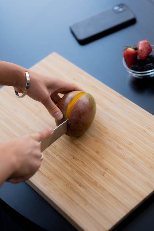 A Person Slicing a Mango