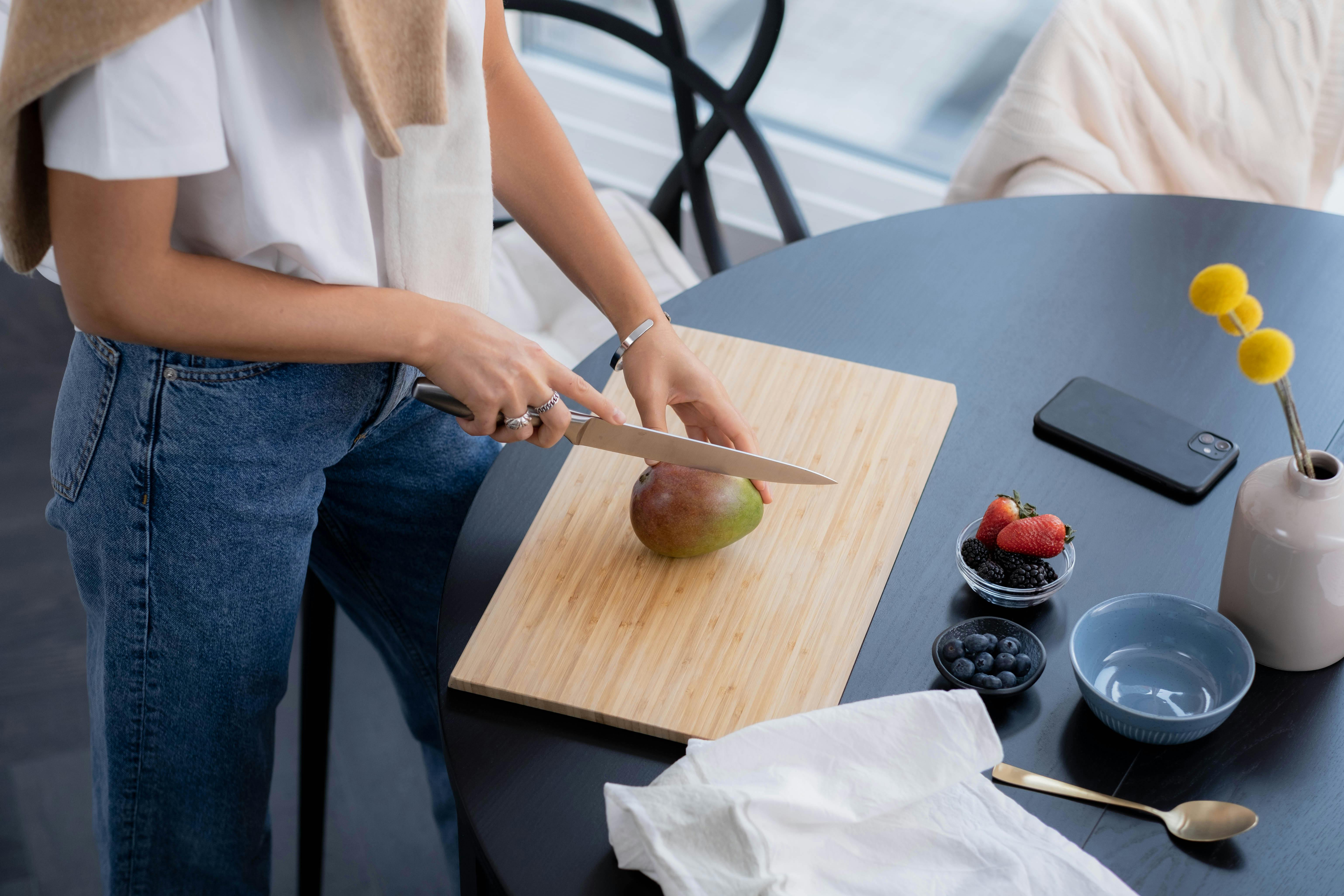 Green Avocado and a Knife on Brown Wooden Chopping Board · Free Stock Photo