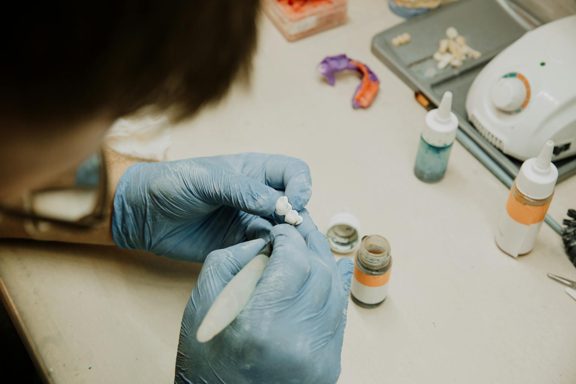 Crop unrecognizable dentist making dental implant in laboratory