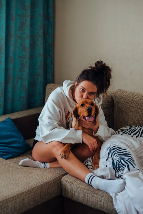 Free Woman cuddle and kissing dog on sofa Stock Photo
