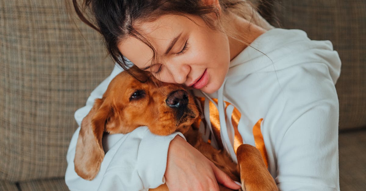 Tender woman hugging obedient dog at home