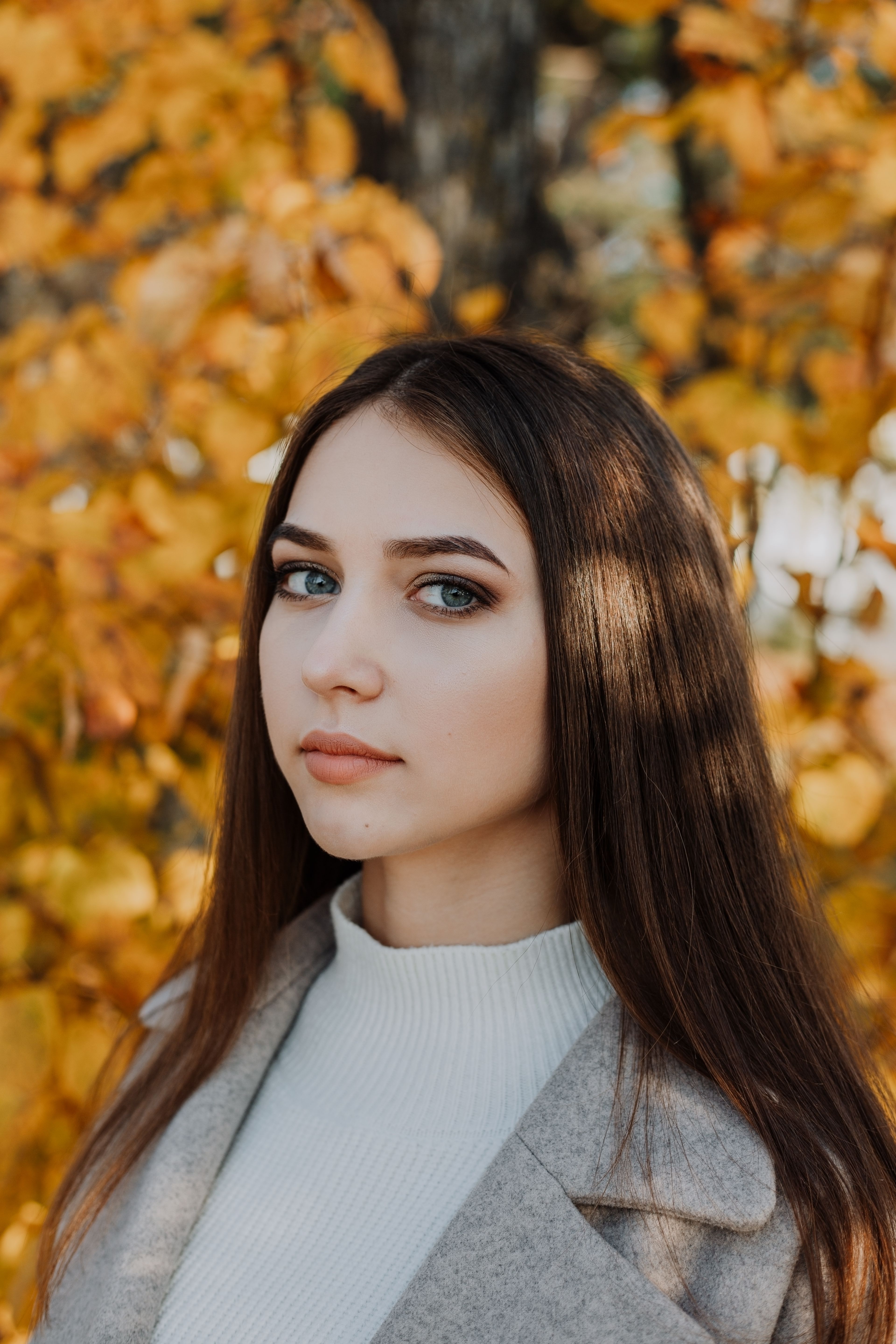 Woman in turtleneck among autumn leaves, fall casual outfit
