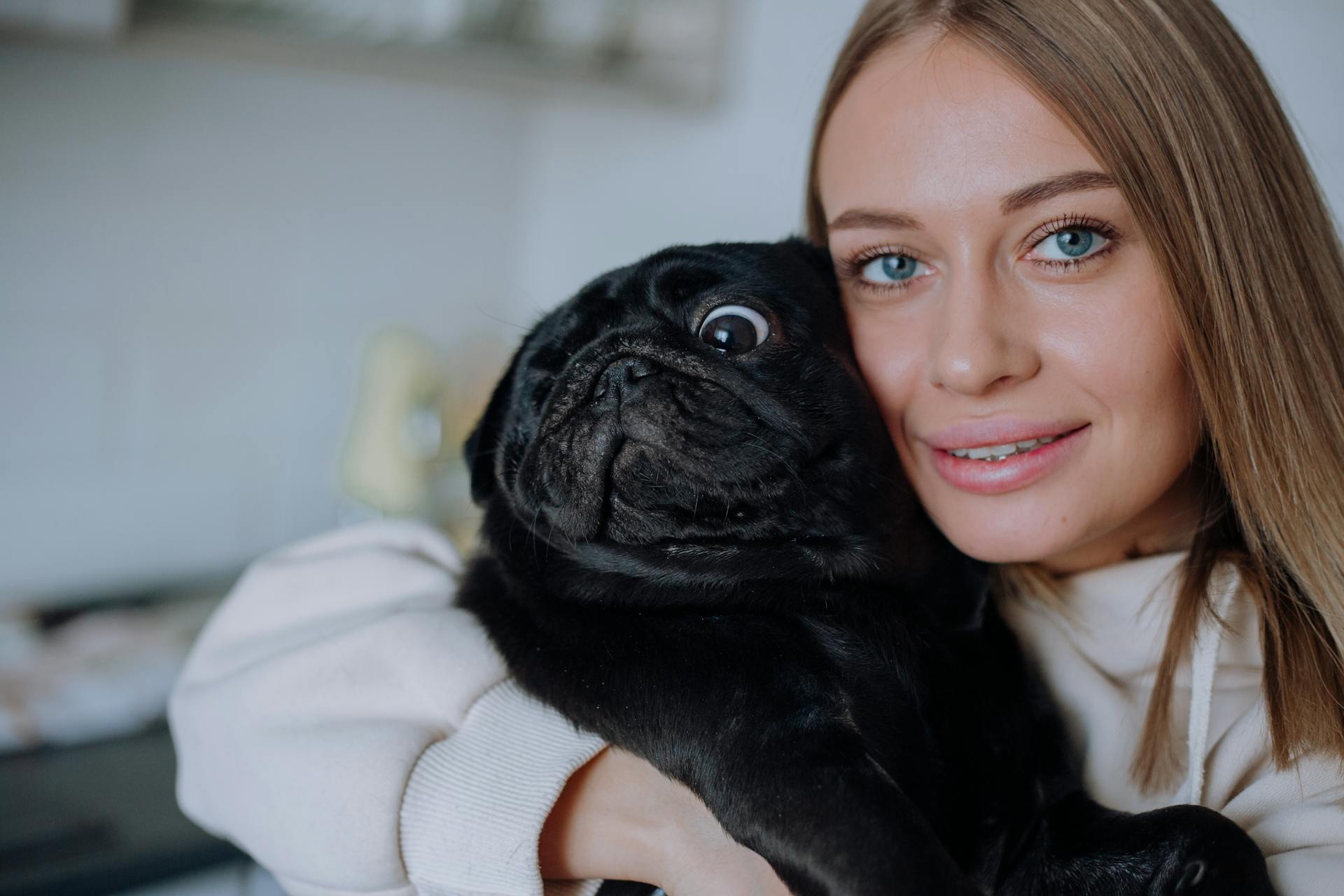 A Woman Hugging Her Pet Pug