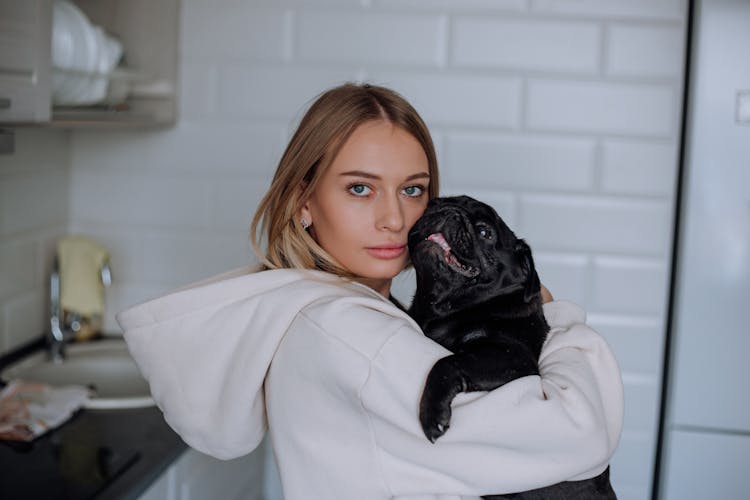 Young Woman Holding A Pug 