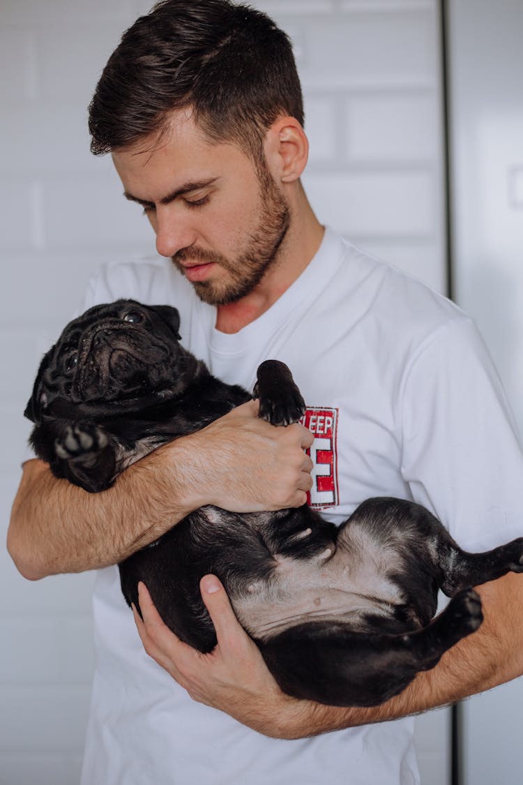 A Bearded Man Holding His Pet Pug