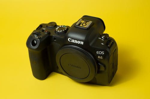 Black Canon Digital Camera on a Yellow Surface