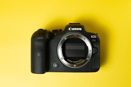 A Black Canon Eos Camera over a Yellow Surface