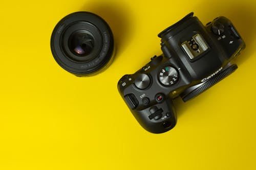 Camera and a Lens on Yellow Background