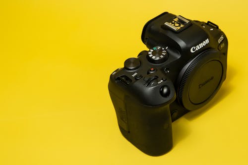 Black Canon Camera over a Yellow Surface